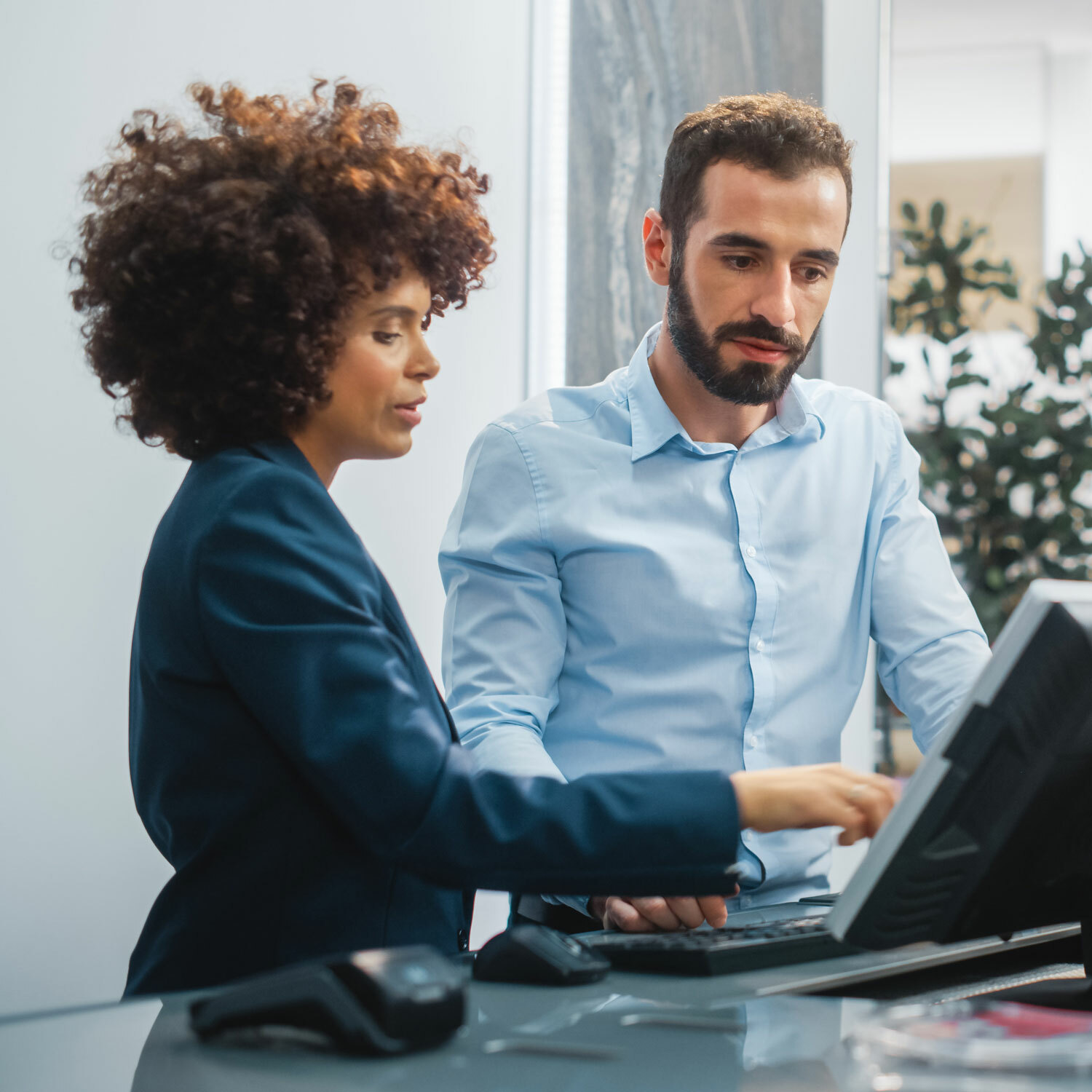 Man and woman at credit union interacting with computer