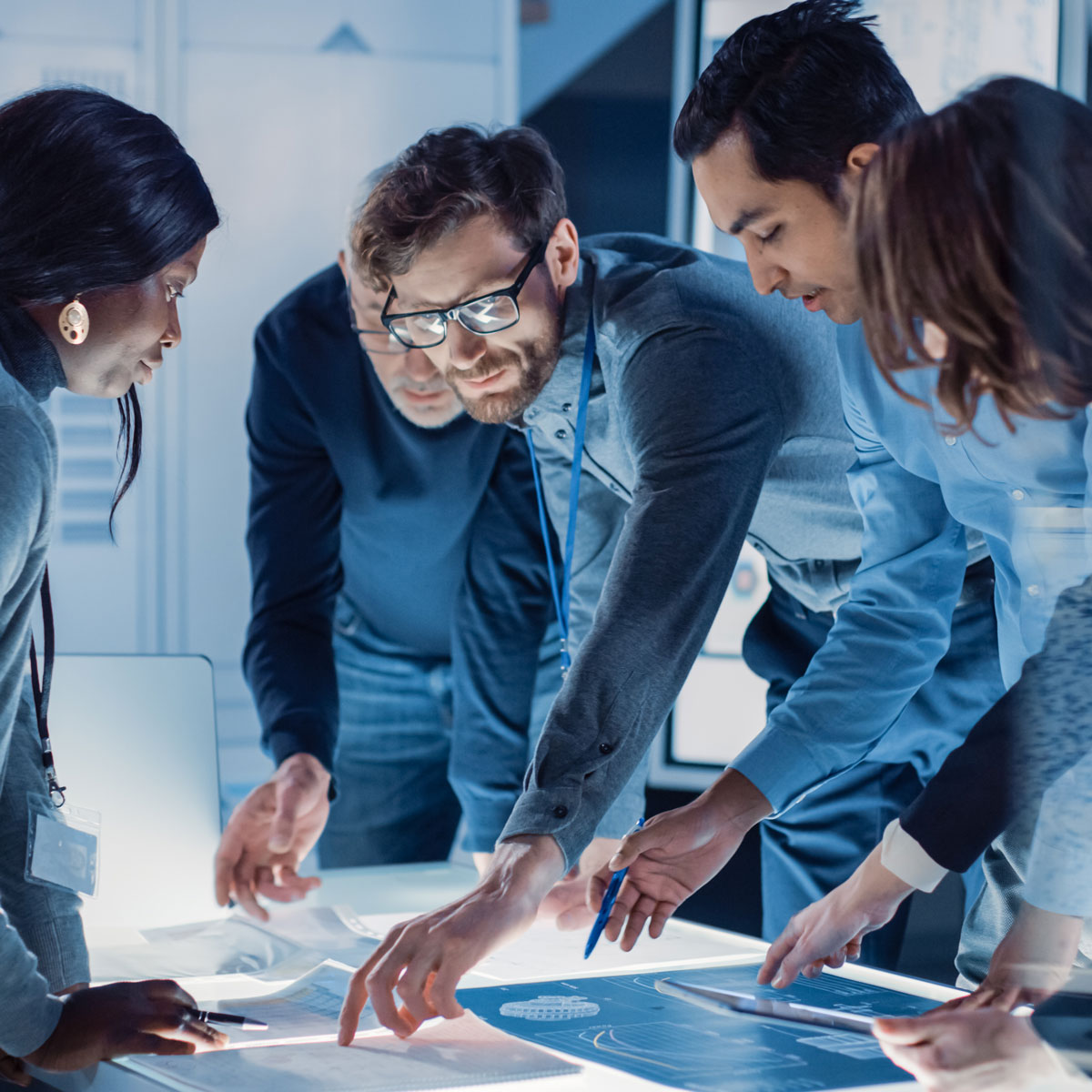 Team collaborating on a custom AI solution, gathered around a table and discussing strategies.