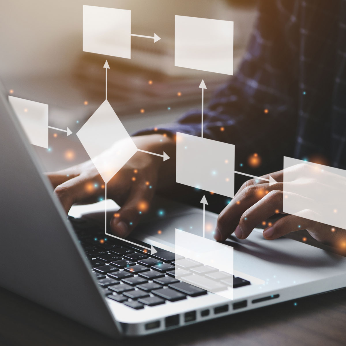 Hands typing on laptop with floating process automation flowchart symbols.