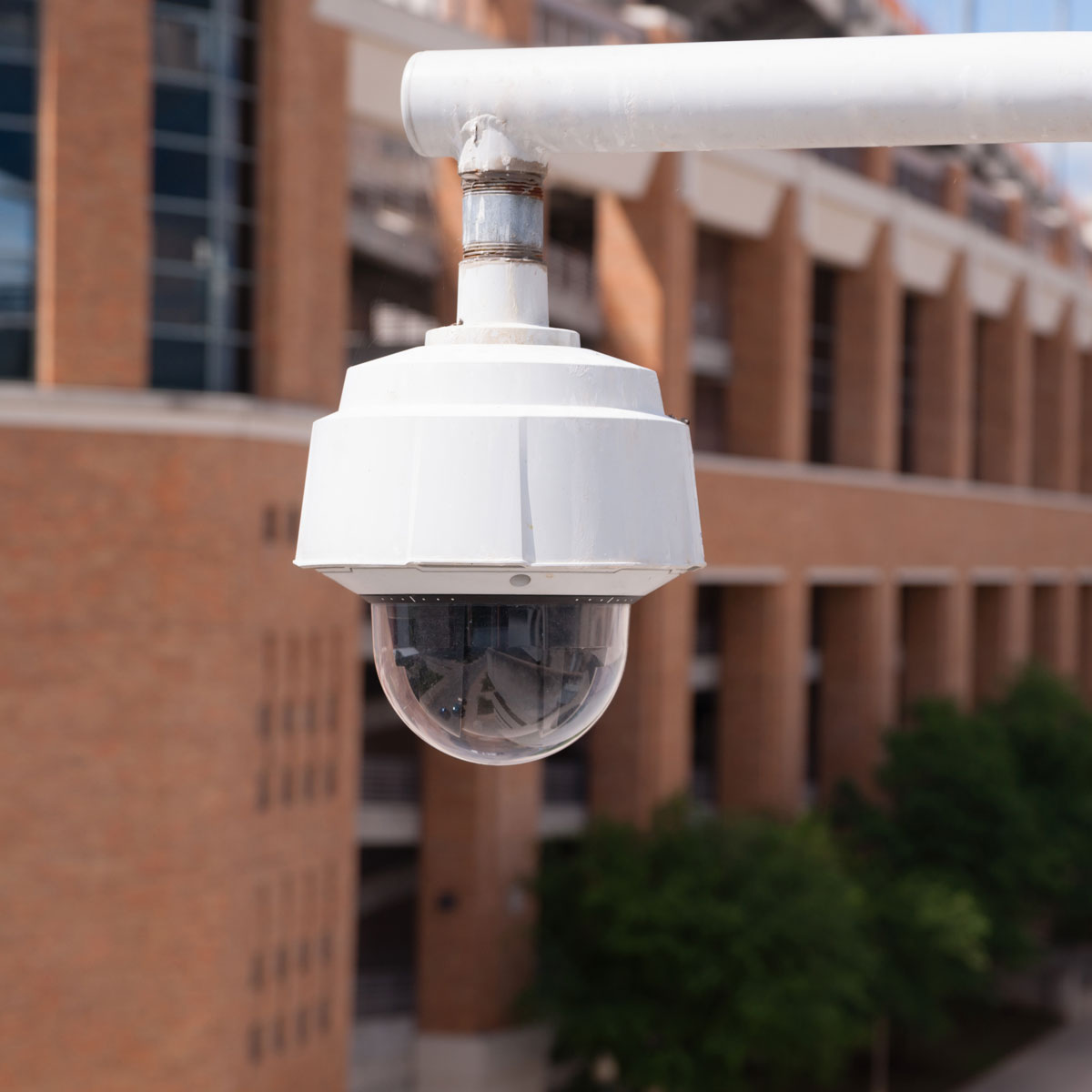Campus security camera enhancing safety near brick building.